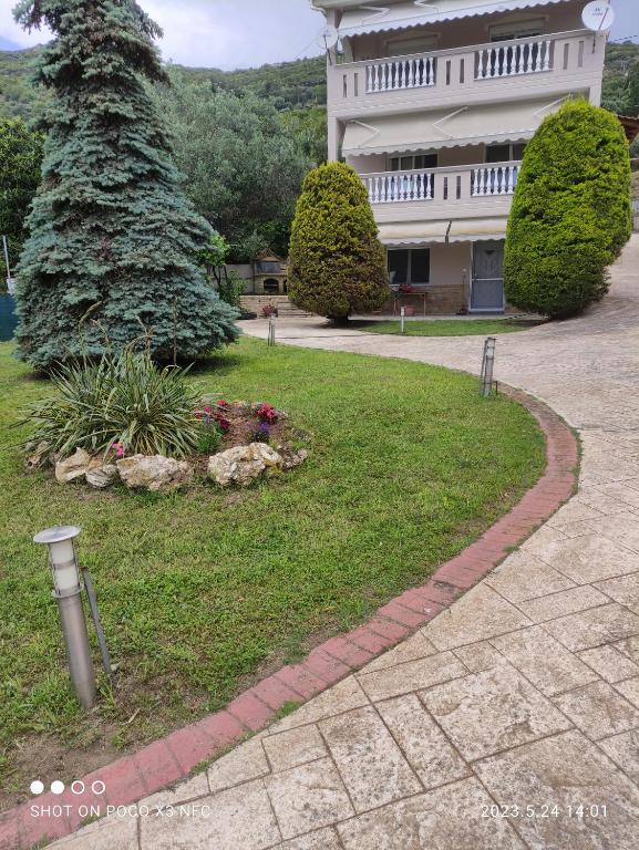 un edificio con árboles y una pasarela en un patio en Garden house, en Palaión Tsiflíkion