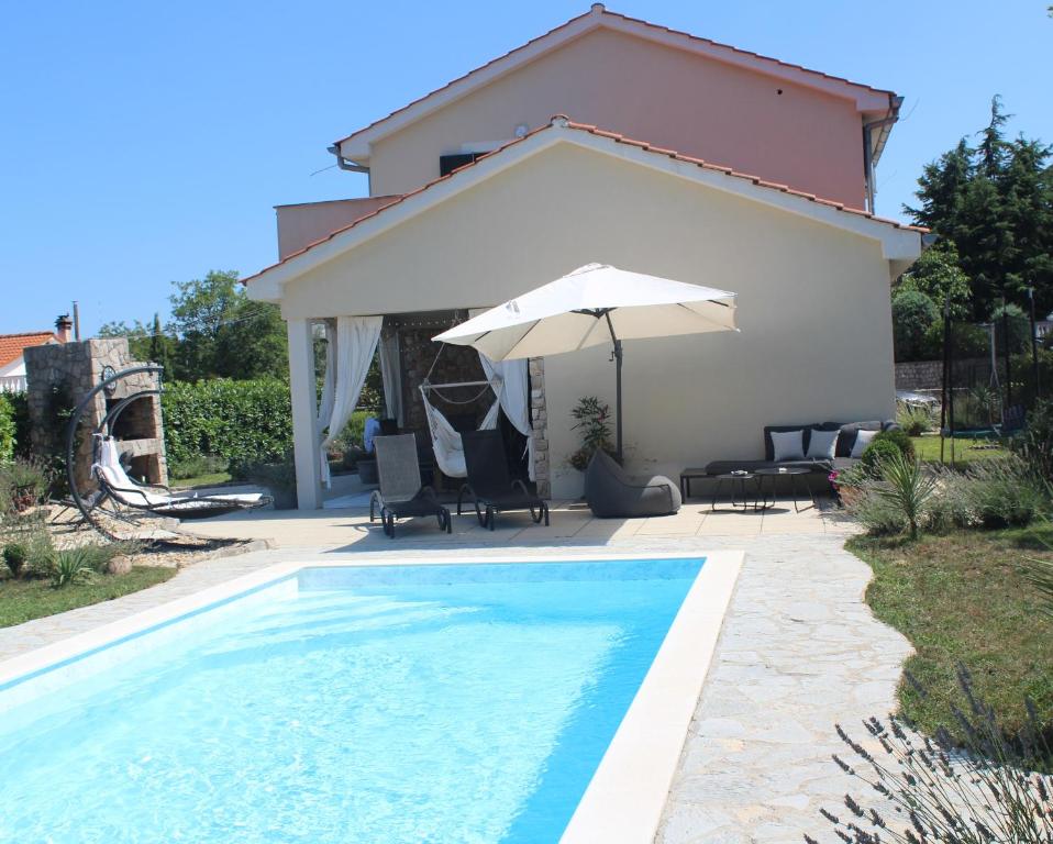 una piscina con sombrilla junto a una casa en Villa Lente, en Polje