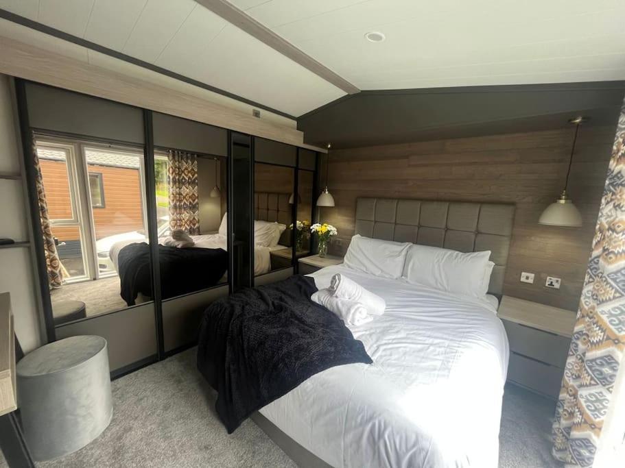 a bedroom with two beds and a large mirror at Field View Lodge with Hot Tub in York