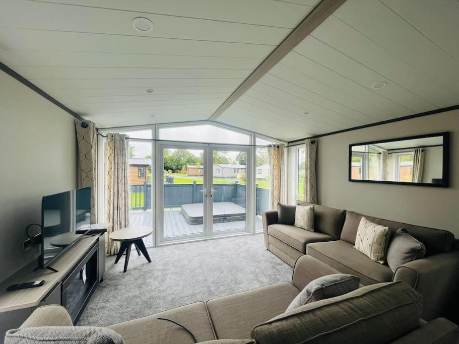 a living room with a couch and a television at Field View Lodge with Hot Tub in York