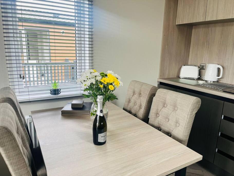 a table in a kitchen with a vase of flowers on it at Field View Lodge with Hot Tub in York