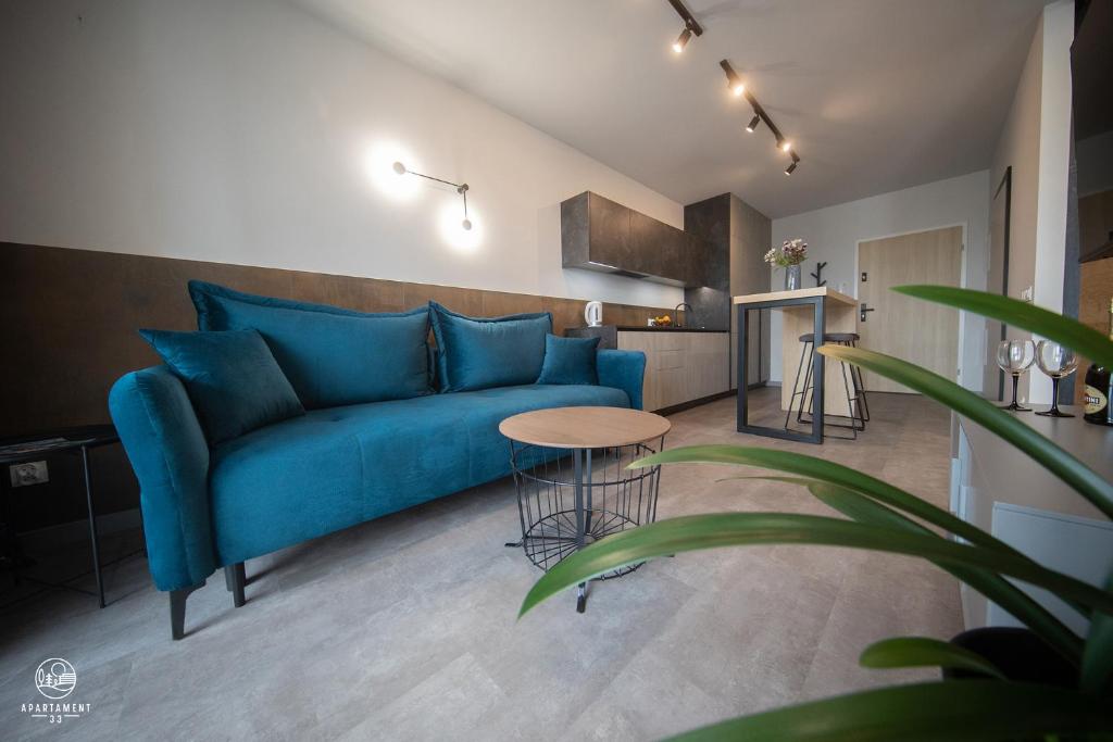a living room with a blue couch and a table at Apartament 33 in Łańcut