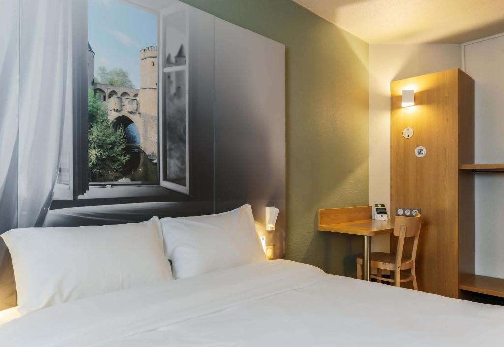 Jouy-aux-ArchesにあるB&B HOTEL Metz Jouy Aux Archesのベッドとテーブルが備わるホテルルームです。