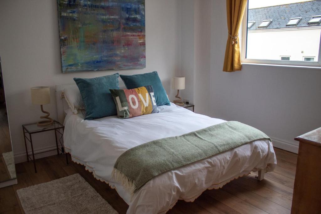 1 dormitorio con cama con almohadas y ventana en Luxury coastal retreat, en Teignmouth