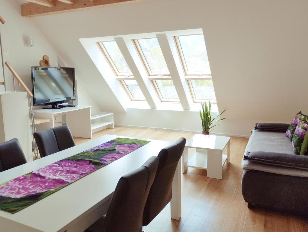 uma sala de estar com uma mesa e um sofá em Apartments Wallas em Bovec