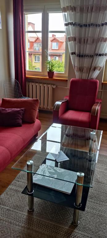 a living room with two couches and a glass table at Apartament Alicji in Ełk