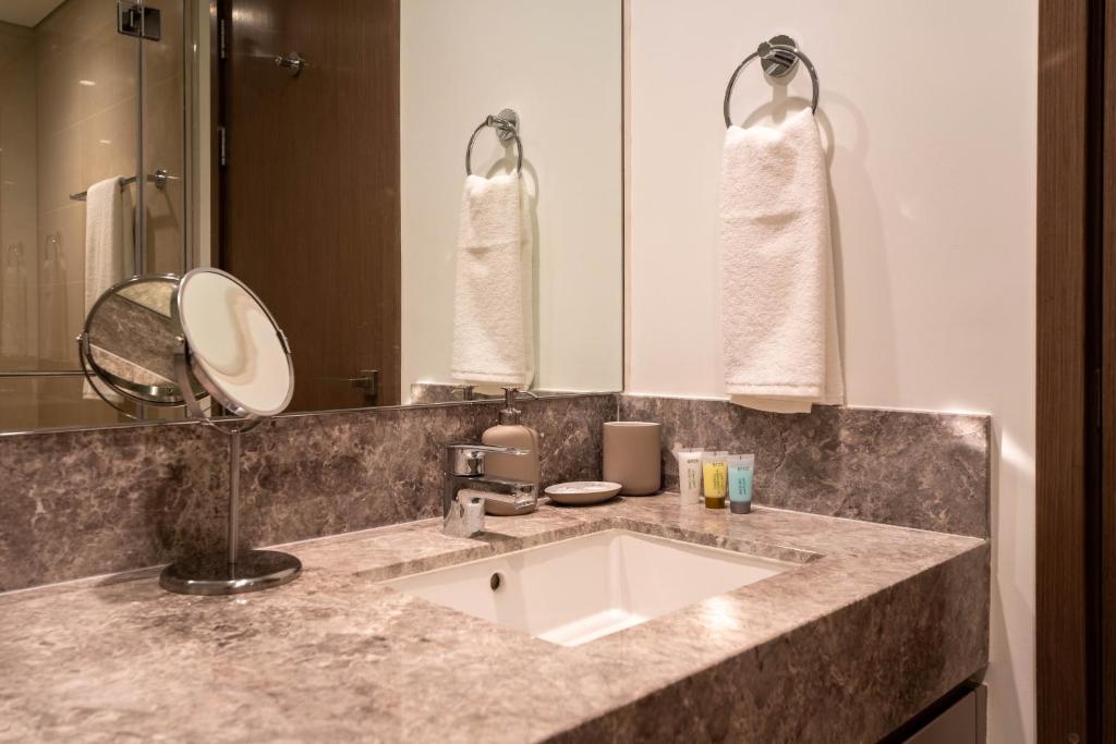 a bathroom with a sink and a mirror at INA Homes - Act 1 Full Burj Khalifa and Fountain Views in Dubai