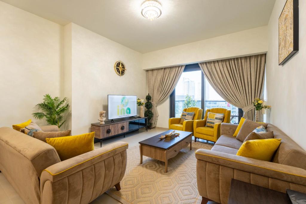 a living room with couches and a flat screen tv at INA Homes - Act 1 Full Burj Khalifa and Fountain Views in Dubai