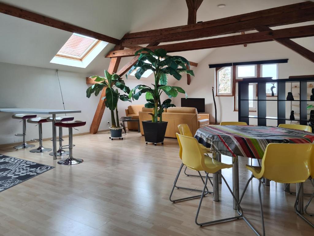 une chambre avec deux tables et des chaises ainsi qu'un salon dans l'établissement Grange Des Arts, à Saint-Nabor