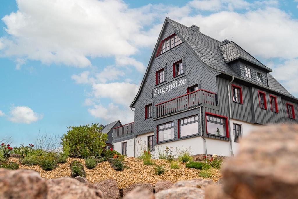 una gran casa en blanco y negro en la cima de una colina en Zugspitze Apartment Weit.Blick en Kurort Altenberg