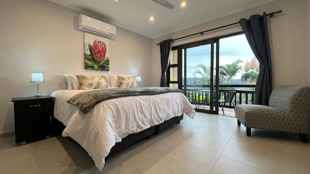 a bedroom with a bed and a window and a chair at Serenity Place Garden View in Durban