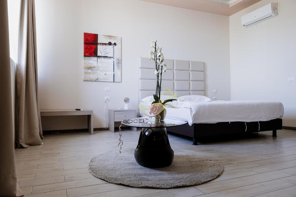 ein Wohnzimmer mit einem Tisch und einem Bett in der Unterkunft Queen Hotel in Sesto San Giovanni