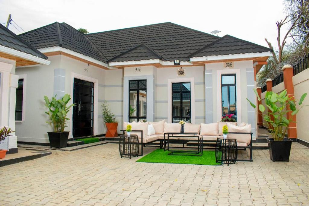 un patio di una casa con mobili bianchi e piante di CACECY LUXURY HOMES a Bungoma
