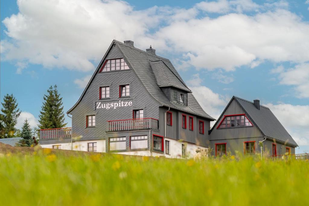 una casa grande en la cima de una colina en Zugspitze Apartment GLÜCK.AUF en Waldidylle