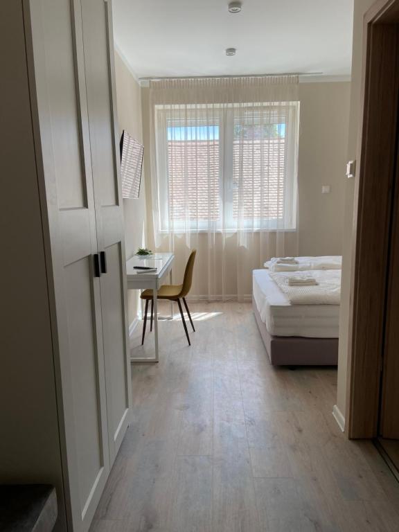 1 dormitorio con cama, escritorio y ventana en H30 Apartman, en Pécs