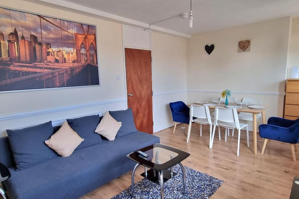 uma sala de estar com um sofá azul e uma mesa em Large Duplex in Bermondsey em Londres