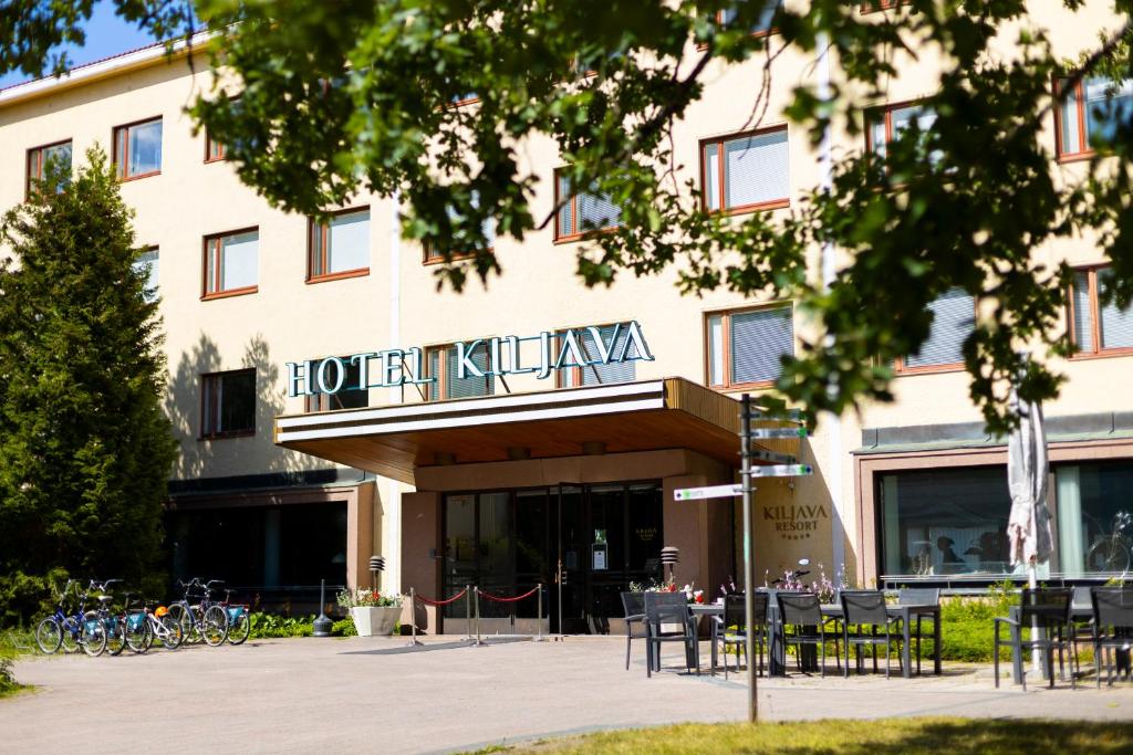 a hotel with tables and chairs in front of a building at Hotel Kiljava in Kiljava