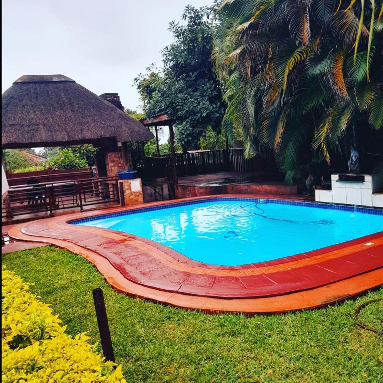 a swimming pool in a yard with a table and a bench at RS GARDEN GUESTHOUSE in Thohoyandou