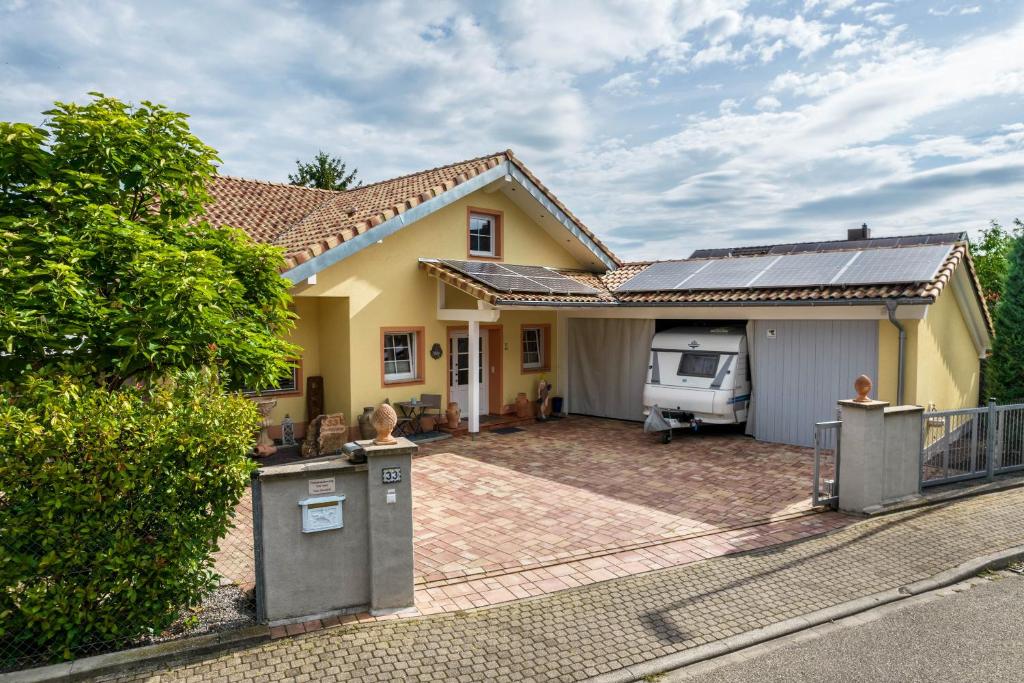a yellow house with a driveway and a garage at Ferienwohnung For two in Mahlberg