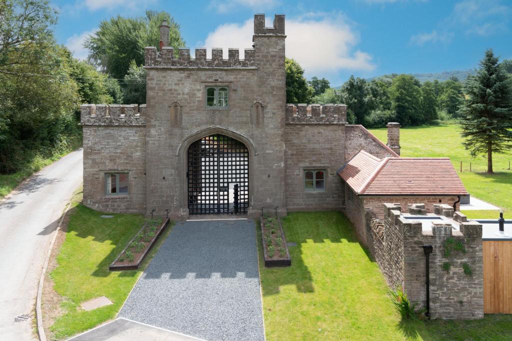 ein altes Schloss mit einem Tor im Hof in der Unterkunft Lower Lodge Gatehouse at Kentchurch 