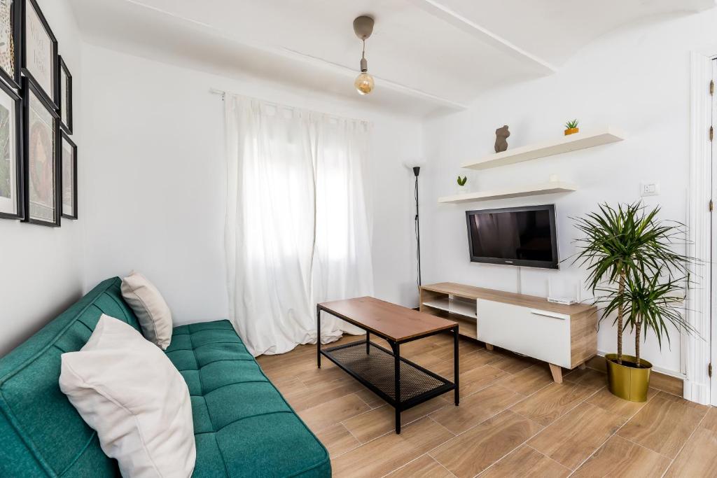 salon z zieloną kanapą i stołem w obiekcie Apartamento en CENTRO CIUDAD w mieście El Puerto de Santa María