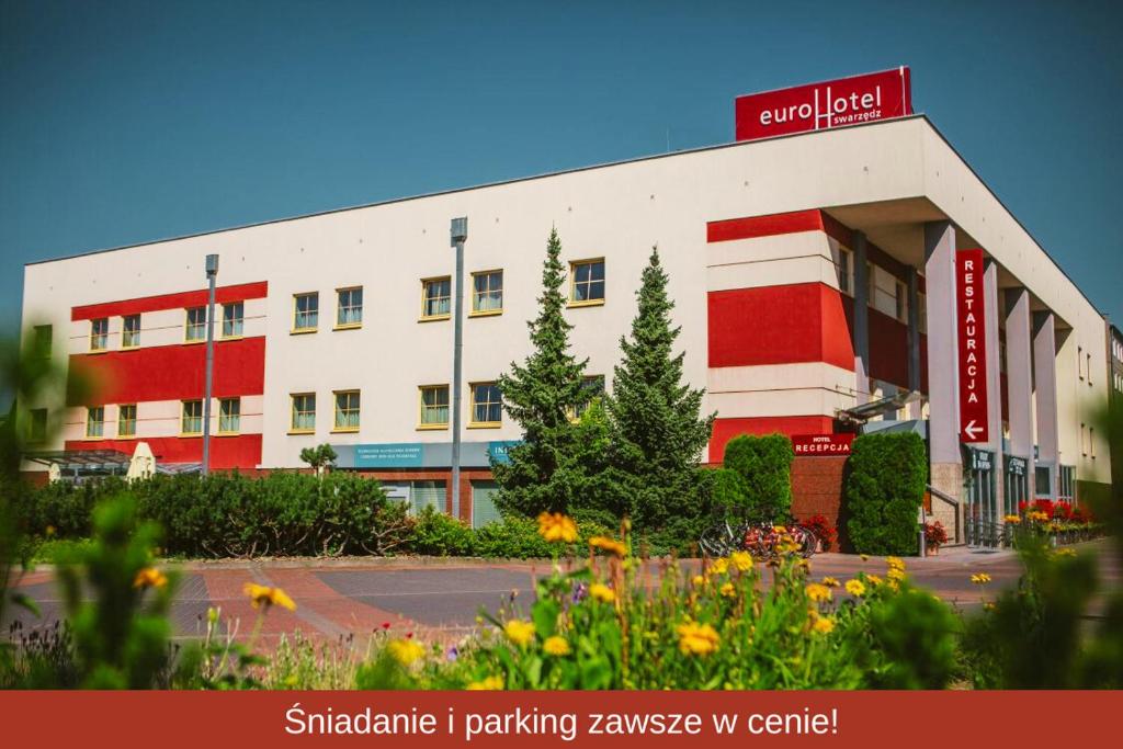 a large building with a red and white at Eurohotel Swarzędz in Swarzędz