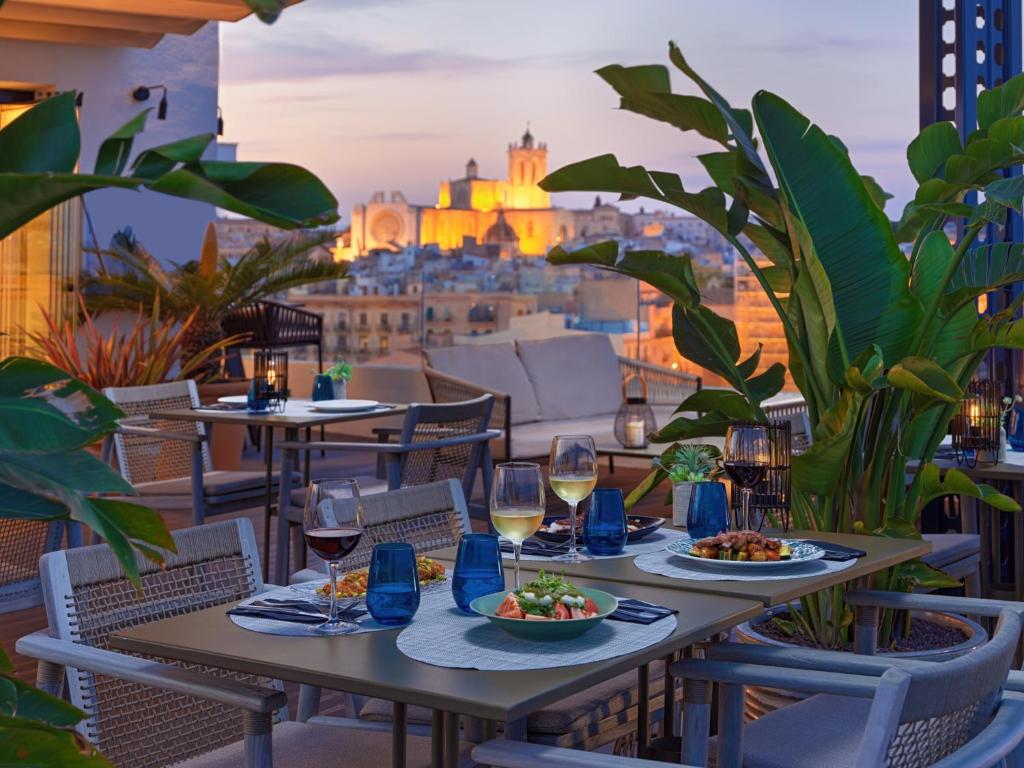 a table with food and wine on a balcony with a view at H10 Imperial Tarraco 4* Sup in Tarragona