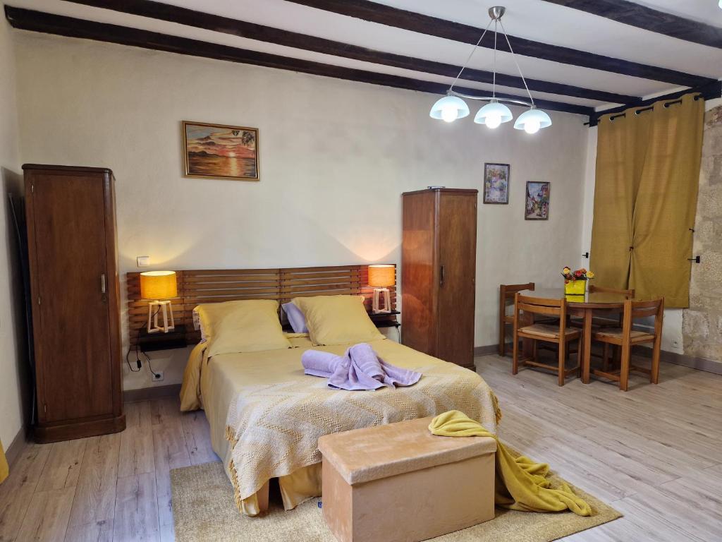 a bedroom with a large bed and a table at Les Flamboyants in Sarlat-la-Canéda