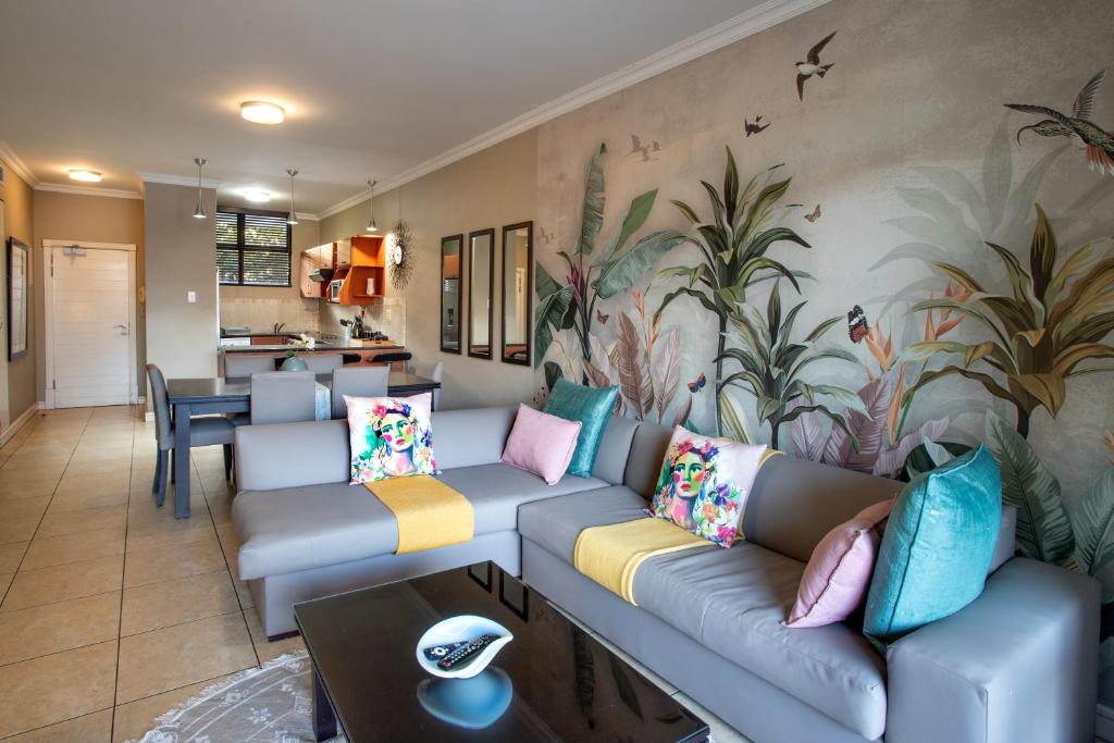 a living room with a couch with colorful pillows at Stay at The Point - Exclusive Executives Escape in Durban