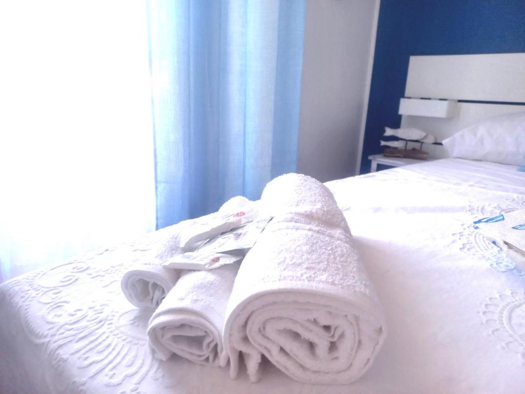 ein Bett mit weißen Handtüchern darüber in der Unterkunft Etrusca shabby chic apartment - Tuscany - Venturina Terme in Venturina Terme