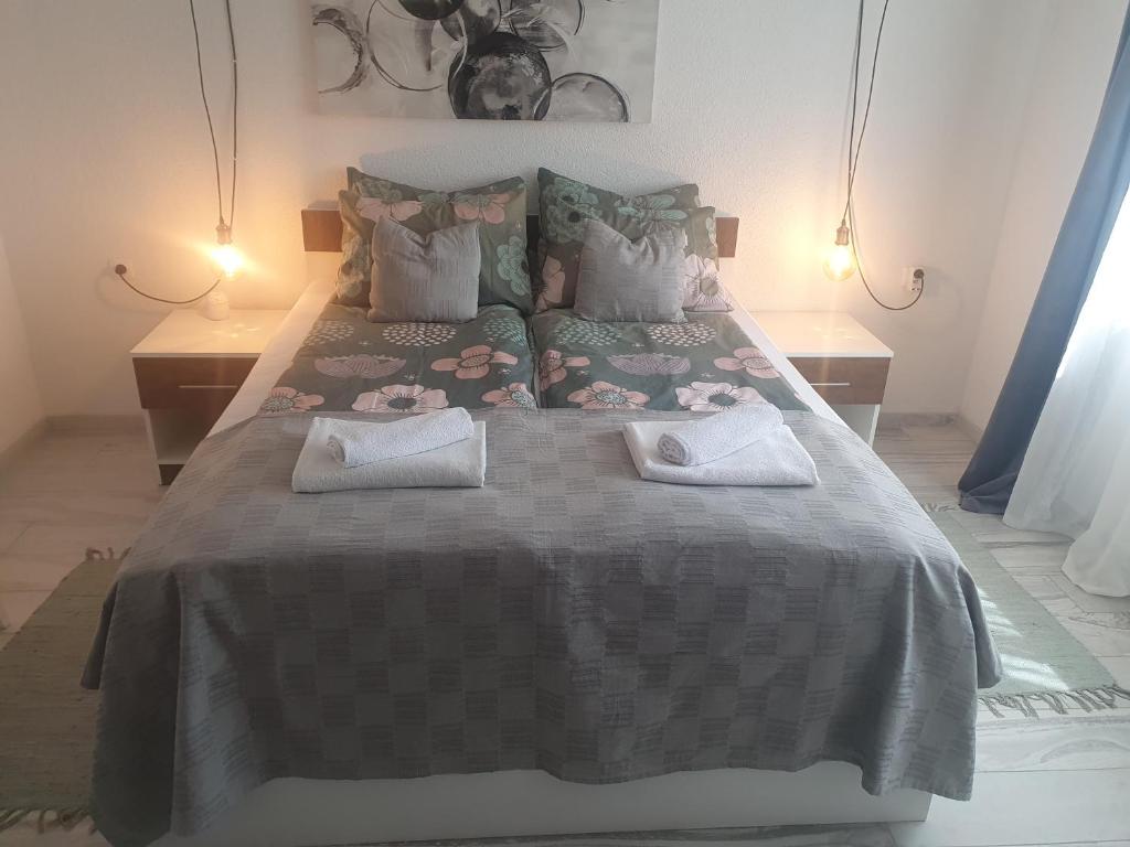 a bedroom with a large bed with two towels on it at Apartman Incerum in Požega