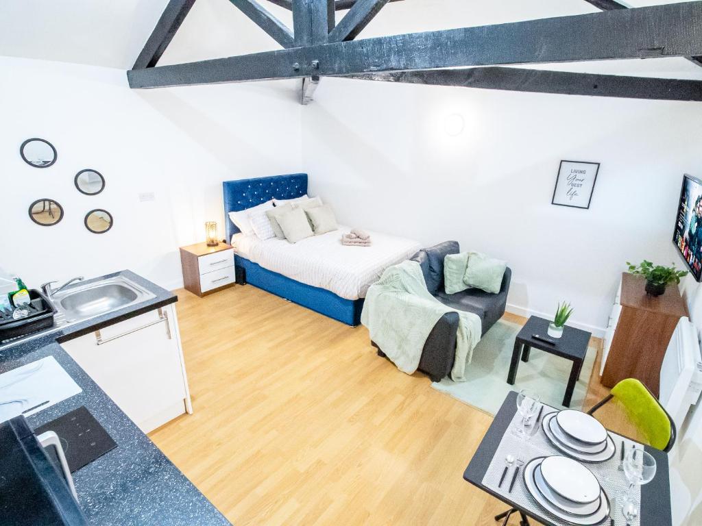 een woonkamer met een bed en een keuken bij Spacious Studio with Parking - 10 Mins to Leeds Centre in Leeds