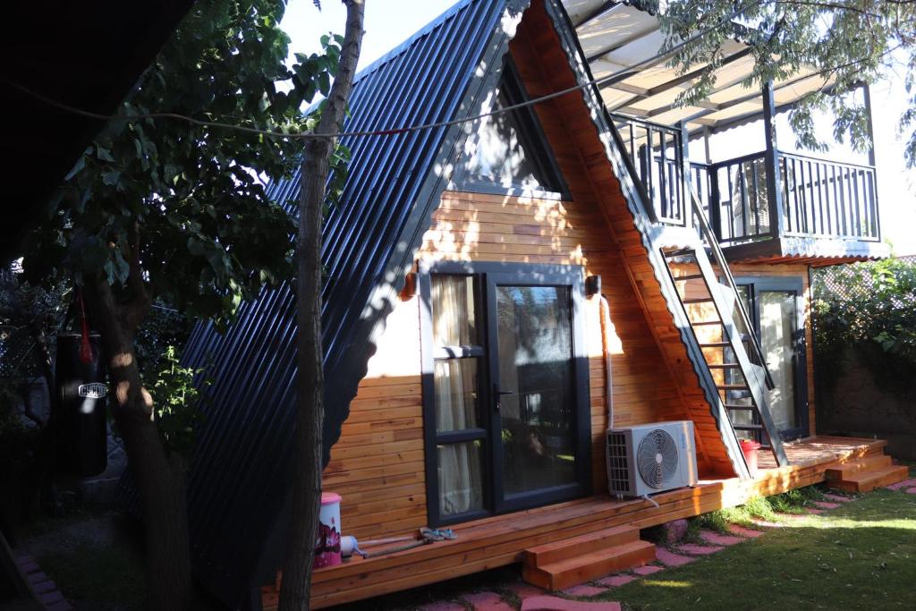 a tiny house with a porch and a balcony at Bedir Kamping in Seferihisar