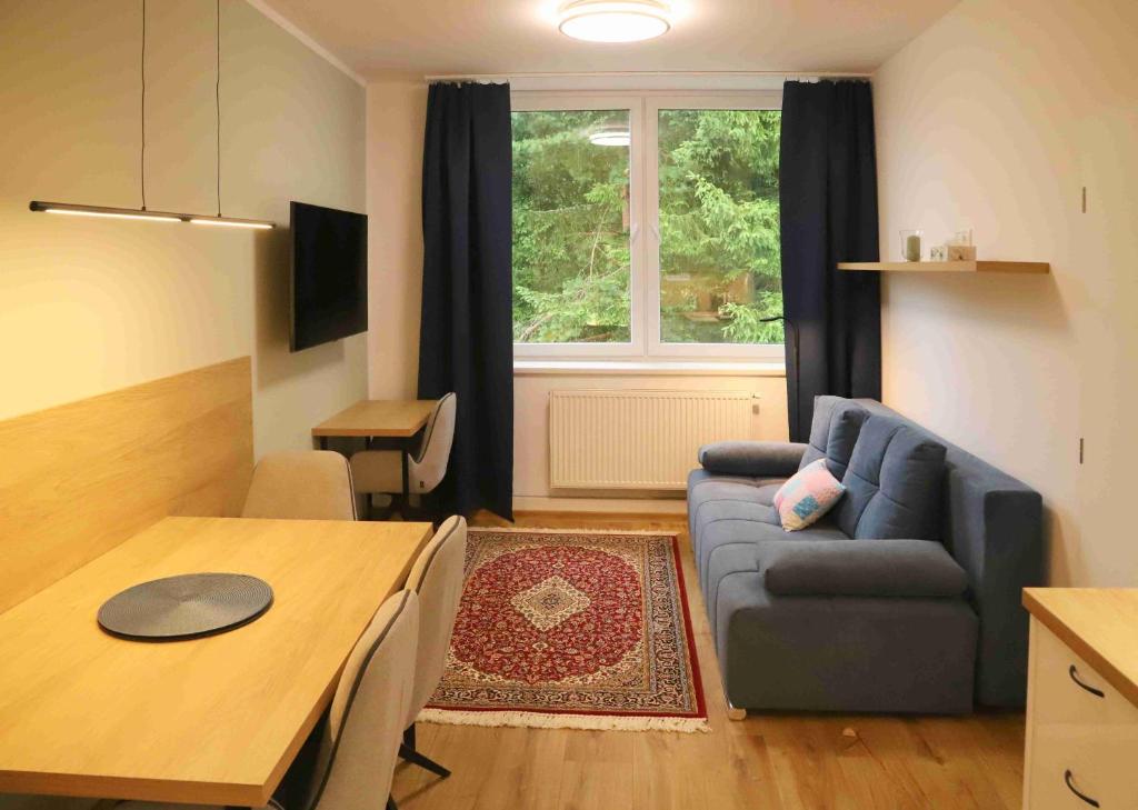 a living room with a blue couch and a table at TOP apartmán Novohradské hory in Černé Údolí