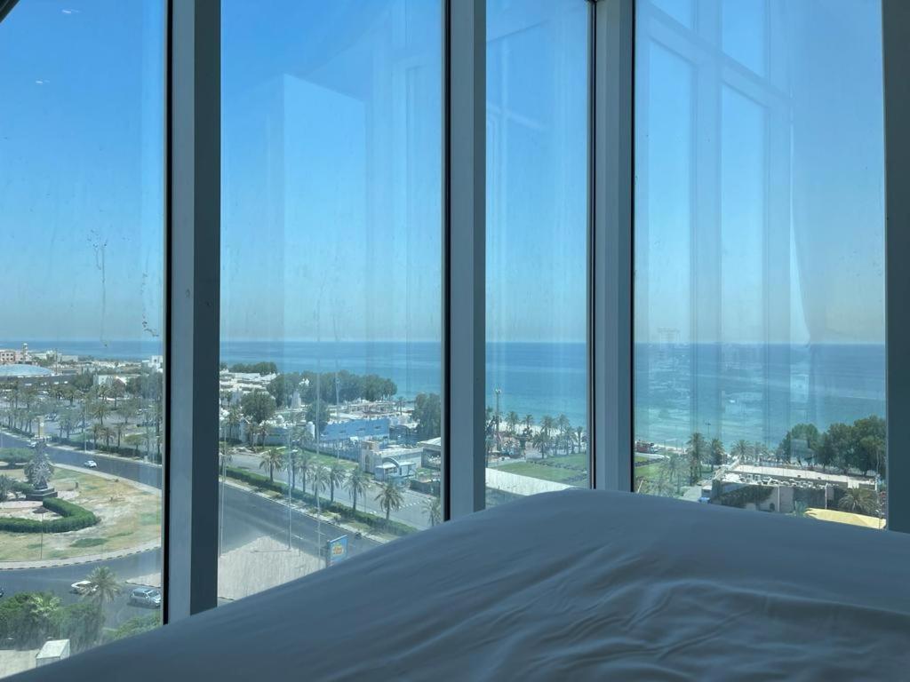 a bedroom with views of the ocean from windows at Gulf grand hotelجلف جراند اوتيل in Kuwait