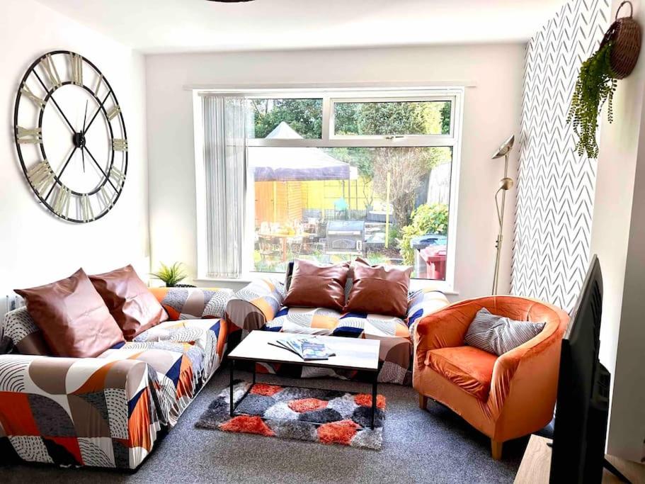 een woonkamer met 2 banken en een raam bij Boss Fab4 Stay &Garden Pro Host in Liverpool