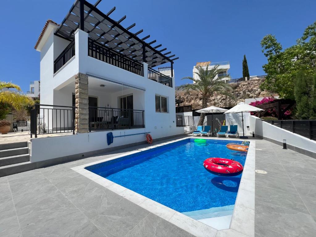 uma villa com piscina em frente a uma casa em Villa Marina Sea-View Private Pool em Pegeia ou Pegya