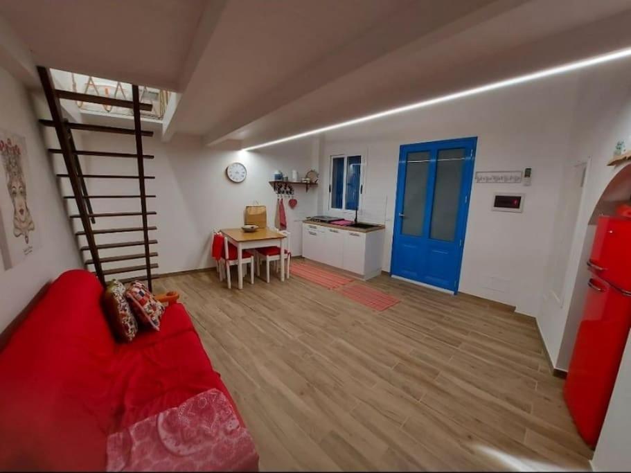 ein Wohnzimmer mit einem roten Sofa und einer Wendeltreppe in der Unterkunft Appartamento Nonno Pit, Marettimo in Marettimo