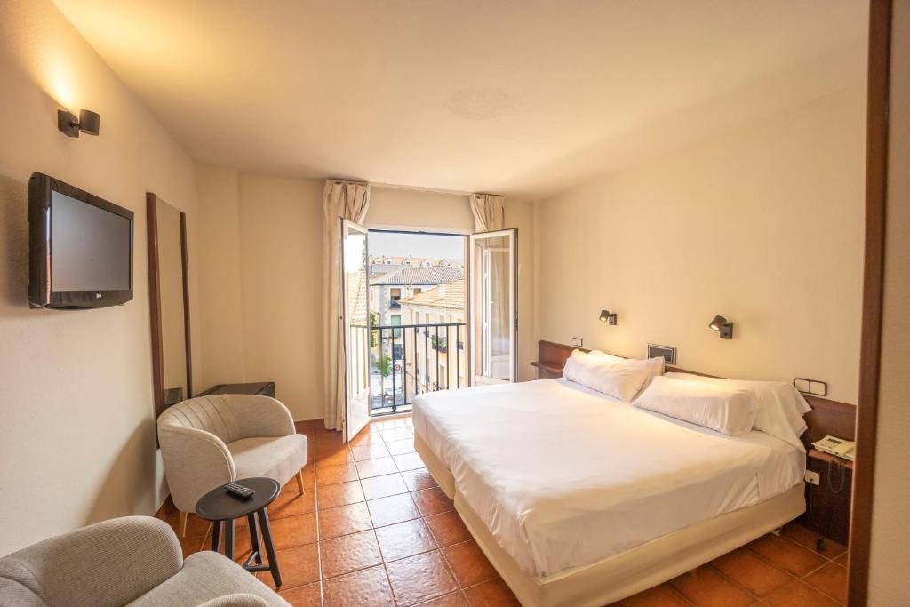 Habitación de hotel con cama y ventana en Hotel Florida en San Lorenzo de El Escorial