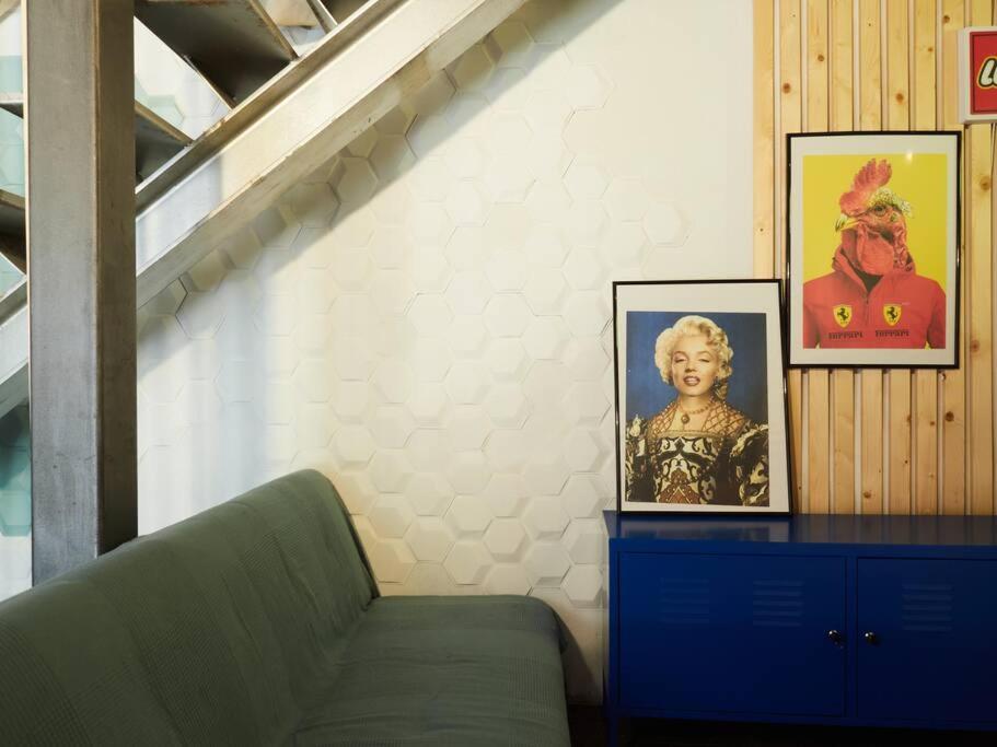 a room with a green couch and pictures on a wall at Cal Jueu. Casa original. in Tarragona
