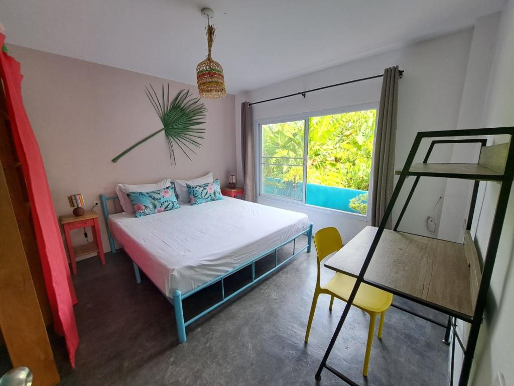 um quarto com uma cama e uma janela em Juliet Home Samui em Ban Lamai