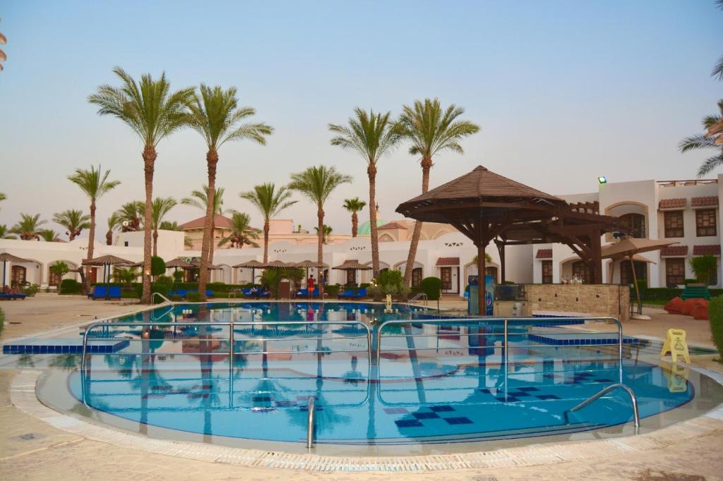 a large swimming pool with palm trees in a resort at Coral Hills Resort Sharm El-Sheikh in Sharm El Sheikh