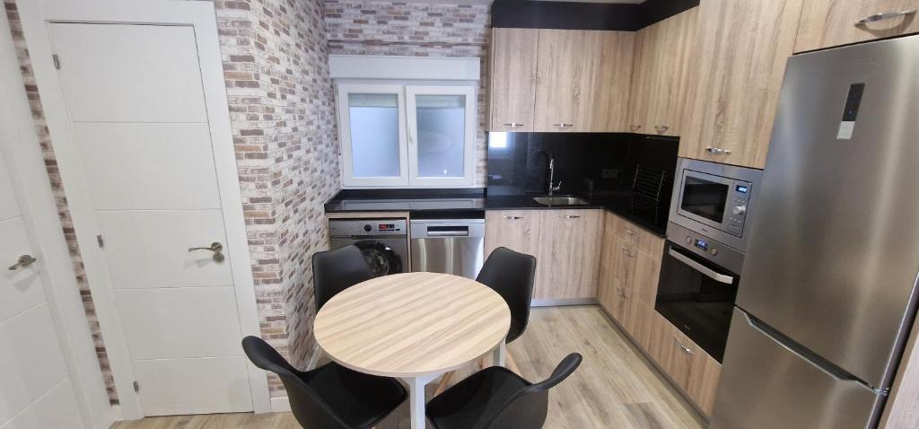 uma pequena cozinha com mesa e cadeiras em Apartamento La Estación - Para 6 em Avilés