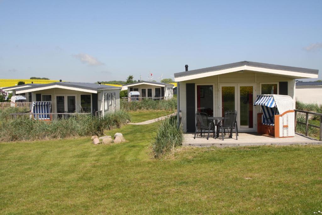 une maison avec deux agneaux posés sur l'herbe dans l'établissement Offizier 18, à Neustadt in Holstein