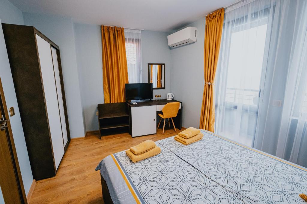 Schlafzimmer mit einem Bett und einem Schreibtisch mit einem TV in der Unterkunft Miletia Suites in Sozopol