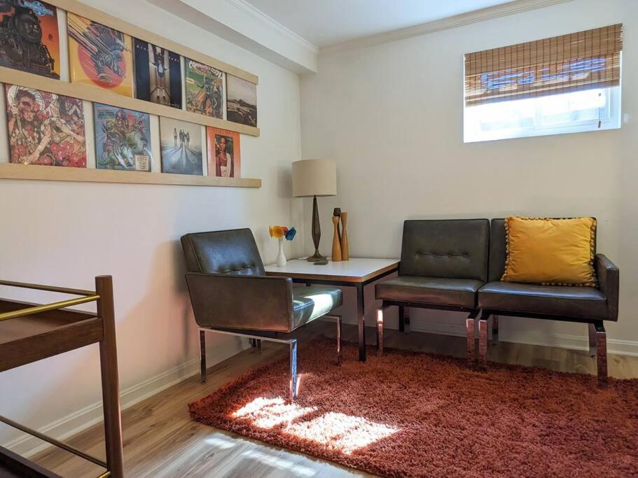 een woonkamer met 2 stoelen en een bureau bij Retro suite with separate office walking- distance to downtown Silver Spring! in Silver Spring