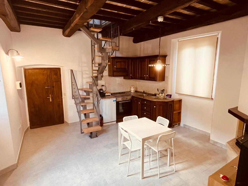 una cocina con mesa y sillas y una escalera en Casa in Umbria - nella Valle del Menotre vicino Rasiglia, Foligno, Assisi,Perugia, en Foligno