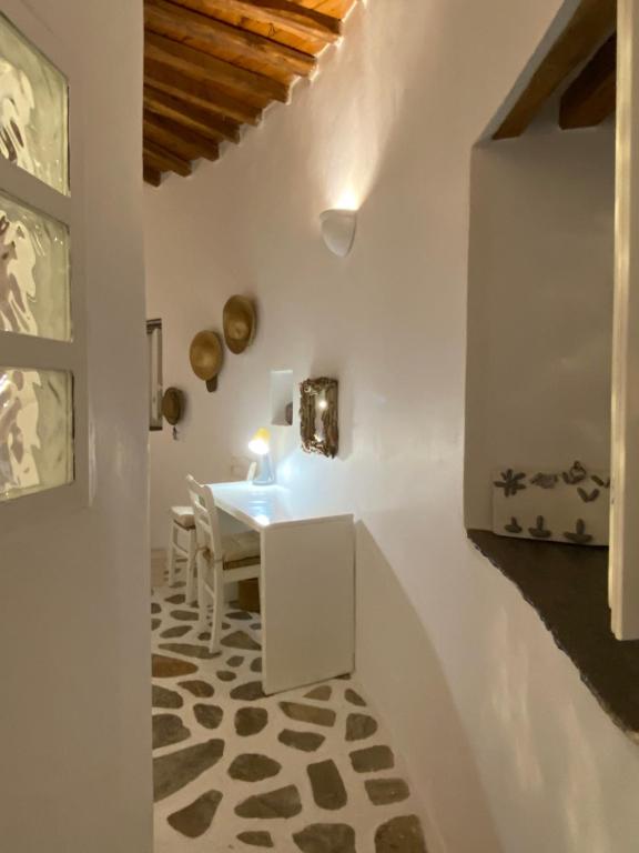 ein Esszimmer mit einem Tisch und einer weißen Wand in der Unterkunft Cybele guesthouse in Chrousa