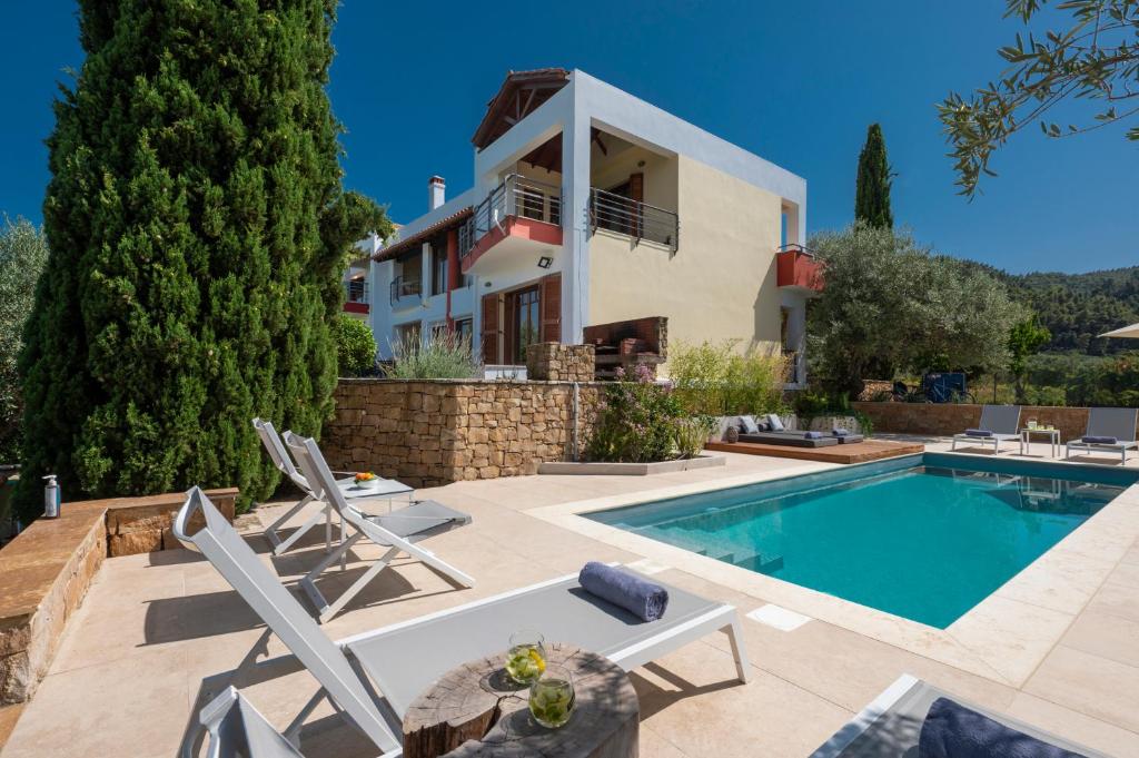 een villa met een zwembad en een huis bij Avista Villa in Vourvourou