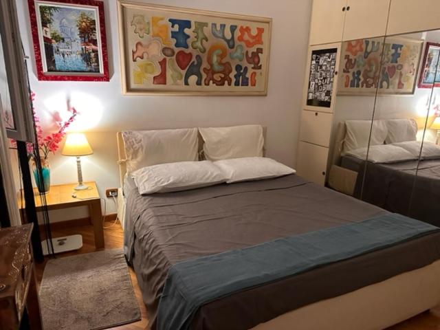 ein Schlafzimmer mit einem Bett und einem Tisch mit einer Lampe in der Unterkunft Cassia Home in Rom
